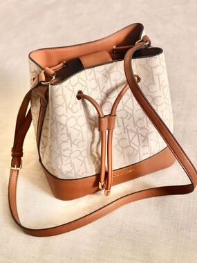 Calvin Klein Cream & Tan Monogram Drawstring Bucket Crossbody.